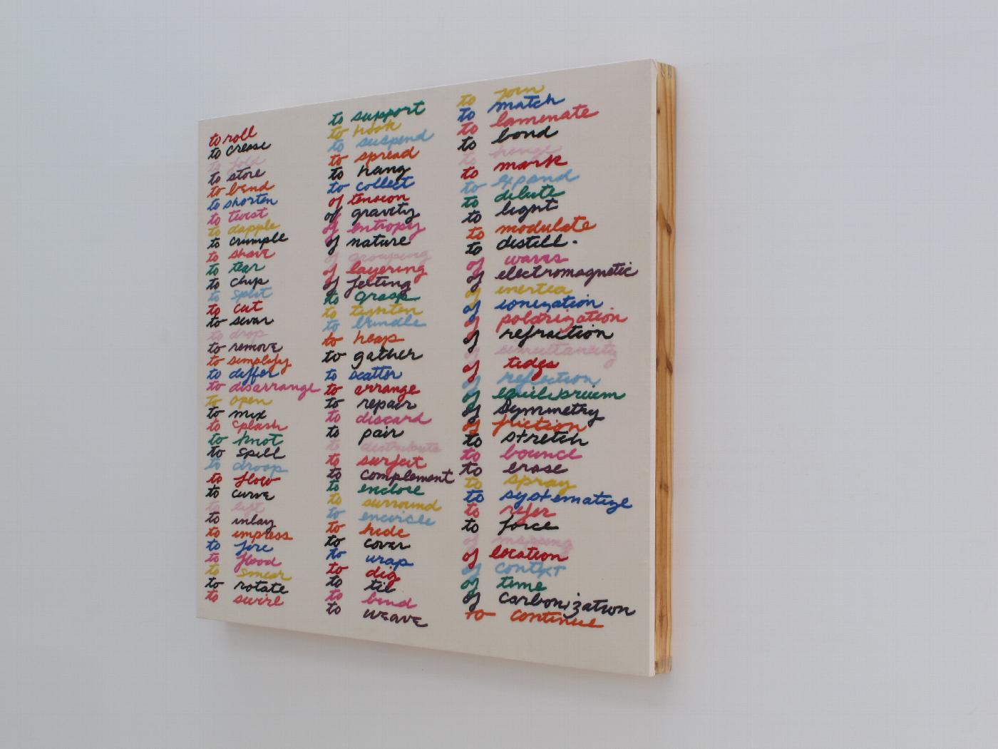 Escultura de Carmen Marcos, un bordado sobre algodón montado en bastidor de madera (2010-2012), que reproduce el listado de verbos de acción relacionados con la escultura manuscrito por Richard Serra en 1968
